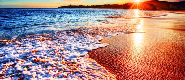Strand mit Wasser und Sonnenuntergang