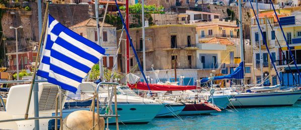 Boot im Hafen mit blau-weißer Flagge von Griechenland
